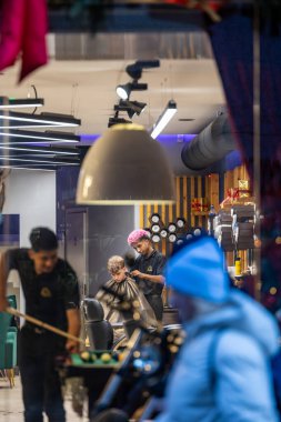 Vilnius, Litvanya 4 Ocak 2025 Bir berber dükkanı içinde müşteriler, berberler ve bilardo oynayan insanlar.