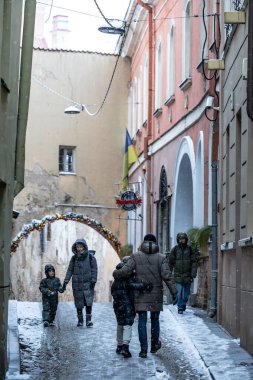 Vilnius, Litvanya 5 Ocak 2025 Eski Twon 'da dar ve karlı bir sokakta yürüyen insanlar.