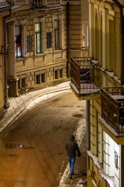 Vilnius, Litvanya 5 Ocak 2025 Eski Şehir 'de karlı bir sokakta yürüyen bir erkek yaya..