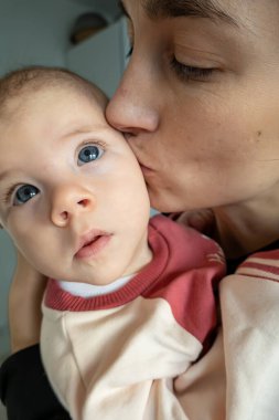 Stockholm, İsveç. 3 aylık bebeğiyle bir annenin portresi..