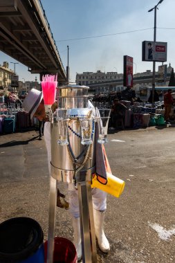 Cairo, Egypt Jan 21, 2025 A water salesman fills glasses from a large water dispenser in the market on Ramsis Square. clipart