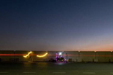 Kahire, Mısır 23 Ocak 2025 Akşamları Kornish Al Mokkatam karayolu ve trafik çizgileri üzerinde aydınlatılmış bir büfe..