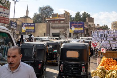 Kahire, Mısır, 24 Ocak 2025 Helwan banliyöleri ve triportör taksilerinde pazarda yürüyen insanlar.