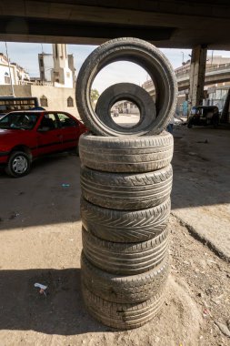 Kahire, Mısır 26 Ocak 2025 Şehrin kuzeyindeki Shubra bölgesinde bir köprünün altındaki otoparkta bir araba lastiği yığını.
