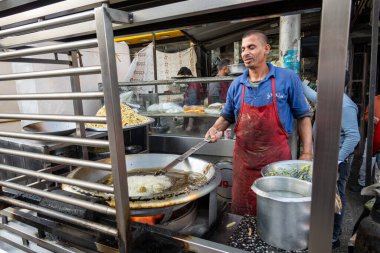 Kahire, Mısır 26 Ocak 2025 Shubra bölgesinin kuzeyindeki bir atet mutfağında aşçı falafel köftelerini yağda kızartıyor..