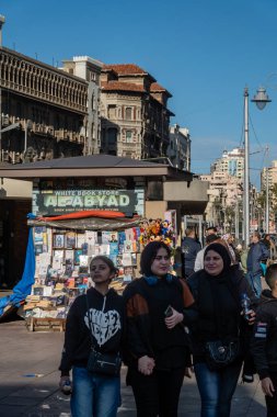 İskenderiye, Mısır 27 Ocak 2025 Üç kadın İskenderiye şehir merkezinde yürüyor El, Mahta Al Raml Meydanı 'nda bir haber büfesi yakınında.