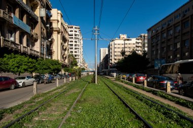 İskenderiye, Mısır 27 Ocak 2025 Tramvay rayları ve şehir merkezinde yeşil çimenler.