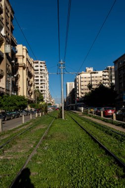 İskenderiye, Mısır 27 Ocak 2025 Tramvay rayları ve şehir merkezinde yeşil çimenler.