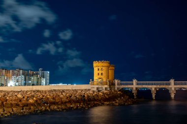 Alexandria, Egypt A night view of ancient stone towers at the Qaitbay Citadel on the Corniche. clipart