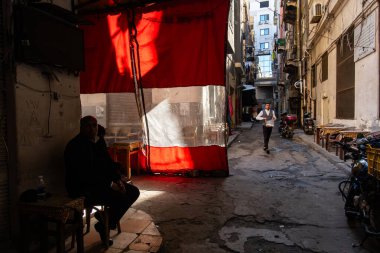 İskenderiye, Mısır 27 Ocak 2025 Bir adam şehir merkezinin arka sokağında gölgede oturuyor.