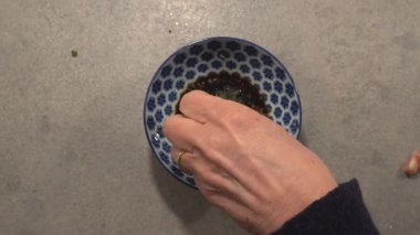Bir aşçı sosu soya, sarımsak, zencefil, balık sosu ve biberle karıştırır.. 