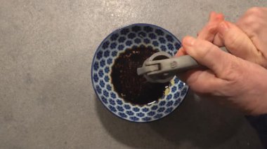 Bir aşçı sosu soya, sarımsak, zencefil, balık sosu ve biberle karıştırır.. 
