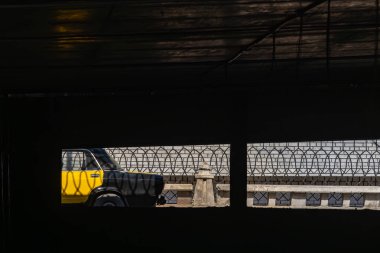 İskenderiye, Mısır 27 Ocak 2025 Bir alt geçitten görülen tipik siyah ve sarı İskenderiye taksisi.