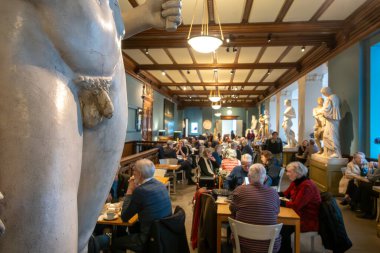 Stockholm, Sweden Jan 31, 2025 People drinking coffee in the cafe at the Konstakademie, or Academy of Fine Arts, building and gallery space. clipart