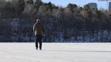 Stockholm, İsveç Lijeholmen bölgesindeki donmuş Trekanten Gölü 'nde bir adam uzun mesafeli buz pateni yapıyor..