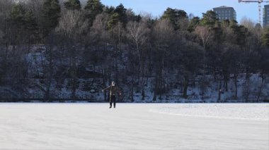 Stockholm, İsveç Lijeholmen bölgesindeki donmuş Trekanten Gölü 'nde bir adam uzun mesafeli buz pateni yapıyor..