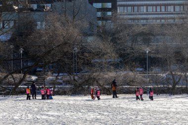 Stockholm, İsveç 19 Şubat 2025 Yansıtıcı yelekli bir grup anaokulu öğrencisi Liljeholmen bölgesindeki Trekanten Gölü 'nde kış buzunda yürüyor..