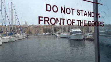 Marsilya, Fransa Le Vieux Limanı 'ndan geçen küçük bir yolcu feribotunun cam pencere ve kapısının manzarası.