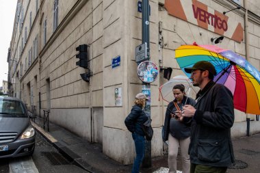 Marsilya, Fransa 14 Mart 2025 Vieux Limanı veya Old Harbour 'da büyük bir şemsiyeyle yürüyen bir adam ve bir kadın..