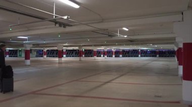 Stockholm, İsveç. Bir adam otoparkta tekerlekli bavulla yürüyor..