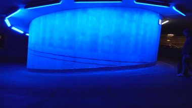 Stockholm, İsveç 'te bir adam mavi bir rampada tekerlekli bavulla yürüyor.. 