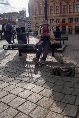 Zagreb, Hırvatistan 24 Mart 2025 Orta Meydandaki bankta oturan şapkalı son sınıf öğrencisi Trg bana Josipa Jelaia.
