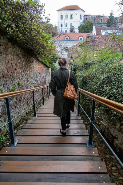 Zagreb, Hırvatistan 24 Mart 2025 Eski kentteki Erkek Stube caddesinde bir kadın dik basamaklardan aşağı yürüyor.