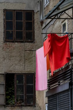 Zagreb, Hırvatistan 24 Mart 2025 Çarşaflar gibi kırmızı çamaşırlar bir iskan binasının balkonundan kurumaya bırakılıyor.