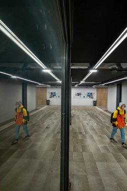 Zagreb, Hırvatistan 24 Mart 2025 Özel çatı ışıklandırmasıyla bir yeraltı geçidinde yürüyen insanlar.