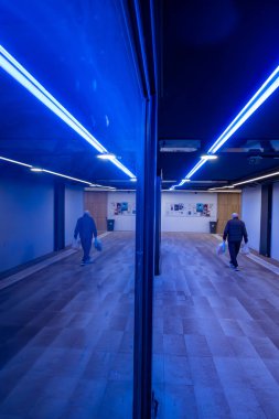 Zagreb, Hırvatistan 24 Mart 2025 Özel çatı ışıklandırmasıyla bir yeraltı geçidinde yürüyen insanlar.