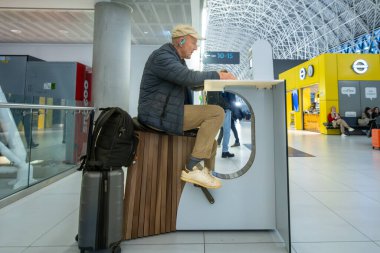 Zagreb, Hırvatistan 28 Mart 2025 Franjo Tudman Havaalanı 'ndaki bir yolcu elektronik cihazını çalıştırmak için elektrikli bisiklet kullanıyor.