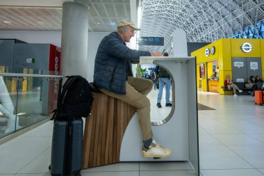 Zagreb, Hırvatistan 28 Mart 2025 Franjo Tudman Havaalanı 'ndaki bir yolcu elektronik cihazını çalıştırmak için elektrikli bisiklet kullanıyor.