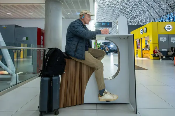 Zagreb, Hırvatistan 28 Mart 2025 Franjo Tudman Havaalanı 'ndaki bir yolcu elektronik cihazını çalıştırmak için elektrikli bisiklet kullanıyor.