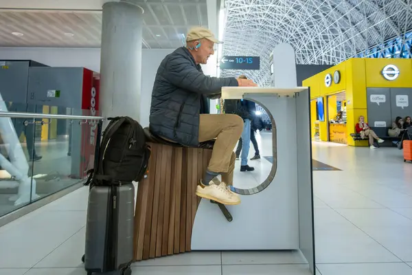 Zagreb, Hırvatistan 28 Mart 2025 Franjo Tudman Havaalanı 'ndaki bir yolcu elektronik cihazını çalıştırmak için elektrikli bisiklet kullanıyor.