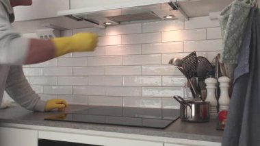 Stockholm, İsveç 'te bir adam ev mutfağında ve hava filtresinde indüksiyon sobası temizliyor.. 