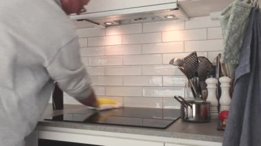 Stockholm, İsveç 'te bir adam ev mutfağında ve hava filtresinde indüksiyon sobası temizliyor.. 