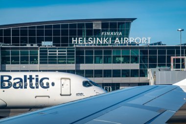 Helsinki, Finlandiya 10 Nisan 2025 Helsinki Havaalanı 'na varış terminali ve bir Air Baltic uçağı.