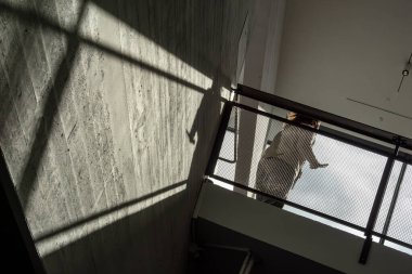 Helsinki, Finlandiya 12 Nisan 2025 Duvarda gölgeler ve siluet içinde yürüyen insanlar.