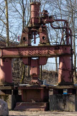 Helsinki, Finlandiya 13 Nisan 2025 Gammelstadsforsen 'de eski ve paslı bir endüstriyel basın anısı olarak duruyor.,