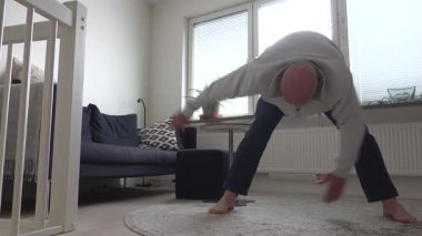 Stockholm, İsveç Bir adam oturma odasında sabah egzersizleri ve jimnastik yapıyor. 