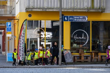 Stockholm, İsveç 24 Nisan 2025 Yansıtıcı yelekli bir grup anaokulu öğrencisi Liljeholmen bölgesinde yürüyor..