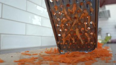 Stockholm, İsveç Tahta üzerinde rendelenmiş havuç rendeleyen bir insan.