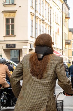 Stockholm, İsveç 28 Nisan 2025 İlgili bir kadın bisikletçi boynuna Hovding hava yastığı takıyor.