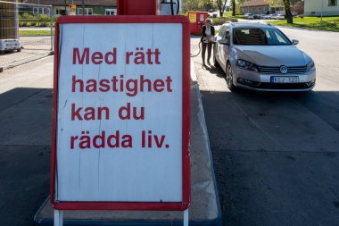 Eskilstuna, İsveç 29 APril 2025 Benzin istasyonunda bir insan benzin dolduruyor ve İsveççe bir işaret diyor ki, 