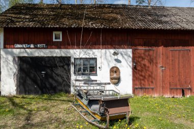 Vinon, İsveç. İkinci el dükkanında kar kızağı olan kırmızı bir ahır. İsveççe 