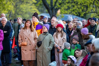 Stockholm, İsveç 30 Nisan 2025 'te kalabalık konuşmaları dinlemek ve Walpurgis gecesini kutlamak için halka açık bir parkta büyük bir şenlik ateşi seyretmek için toplandı..