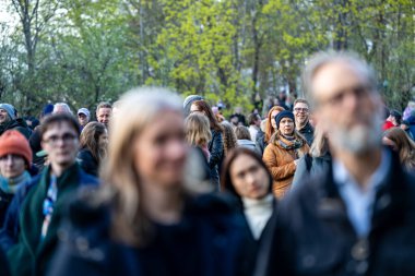 Stockholm, İsveç 30 Nisan 2025 'te kalabalık konuşmaları dinlemek ve Walpurgis gecesini kutlamak için halka açık bir parkta büyük bir şenlik ateşi seyretmek için toplandı..