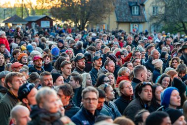 Stockholm, İsveç 30 Nisan 2025 'te kalabalık konuşmaları dinlemek ve Walpurgis gecesini kutlamak için halka açık bir parkta büyük bir şenlik ateşi seyretmek için toplandı..