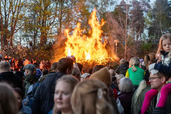 Stockholm, İsveç 30 Nisan 2025 'te kalabalık konuşmaları dinlemek ve Walpurgis gecesini kutlamak için halka açık bir parkta büyük bir şenlik ateşi seyretmek için toplandı..