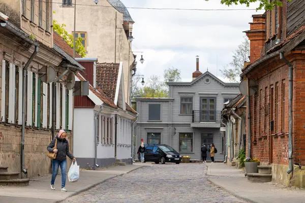 Kuldiga, Letonya MAY 6, 2025 Şehir merkezindeki tarihi bir sokakta yürüyen yayalar.